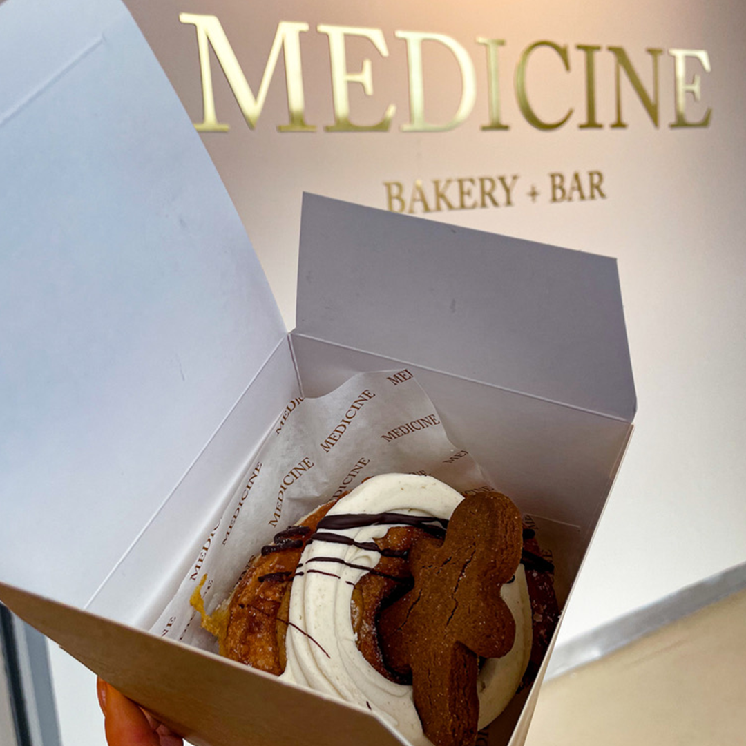 Gingerbread man cronut in a box against a white wall