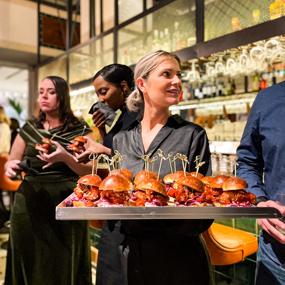 Waitress holding tray of sliders